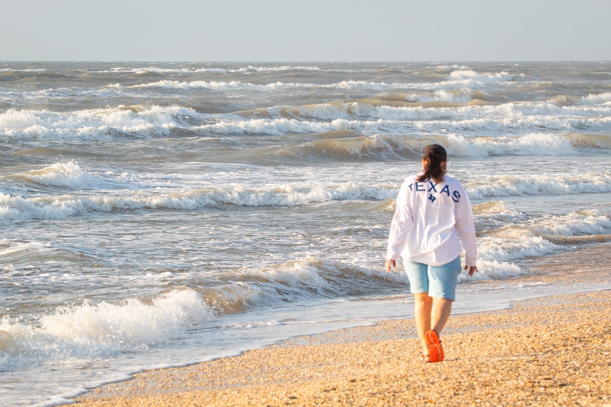 Woman walks along the shore in Corpus Christi